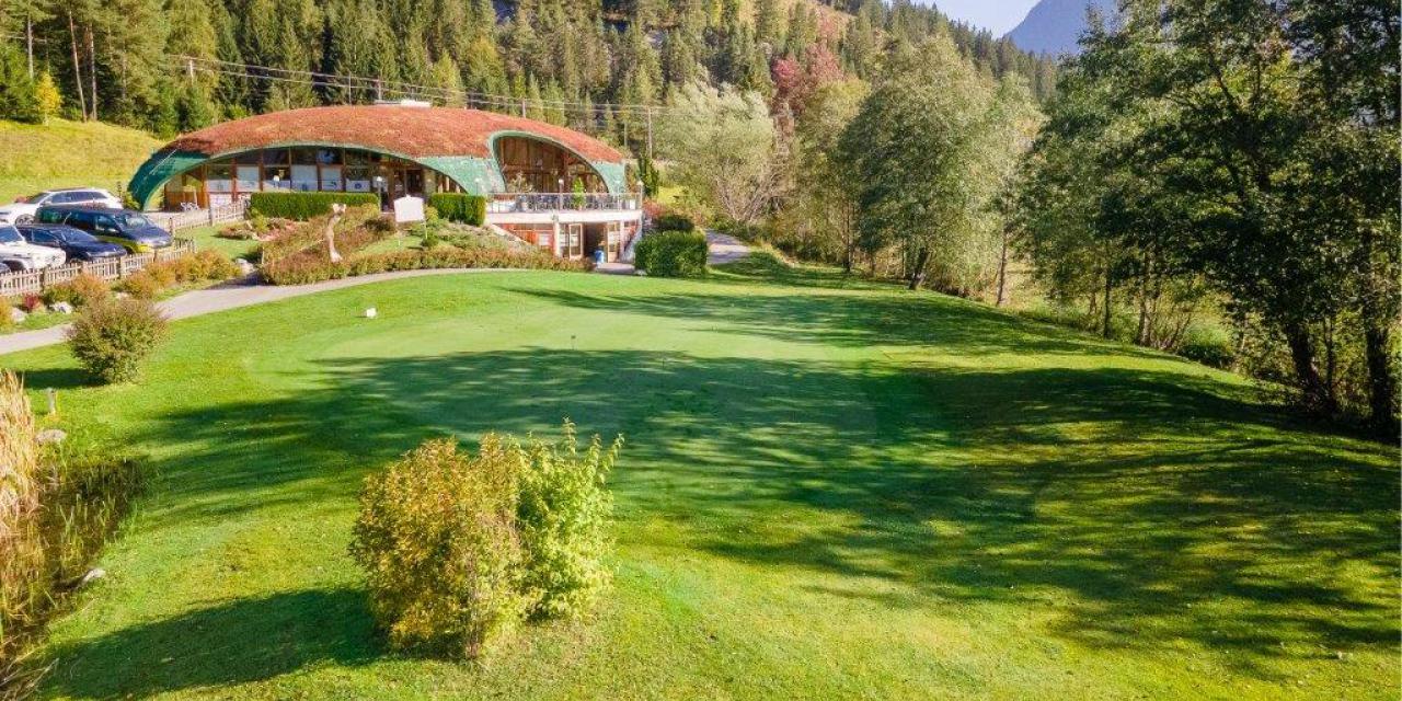 Putting Green mit Clubhaus im Hintergrund Putting Green mit Clubhaus im Hintergrund